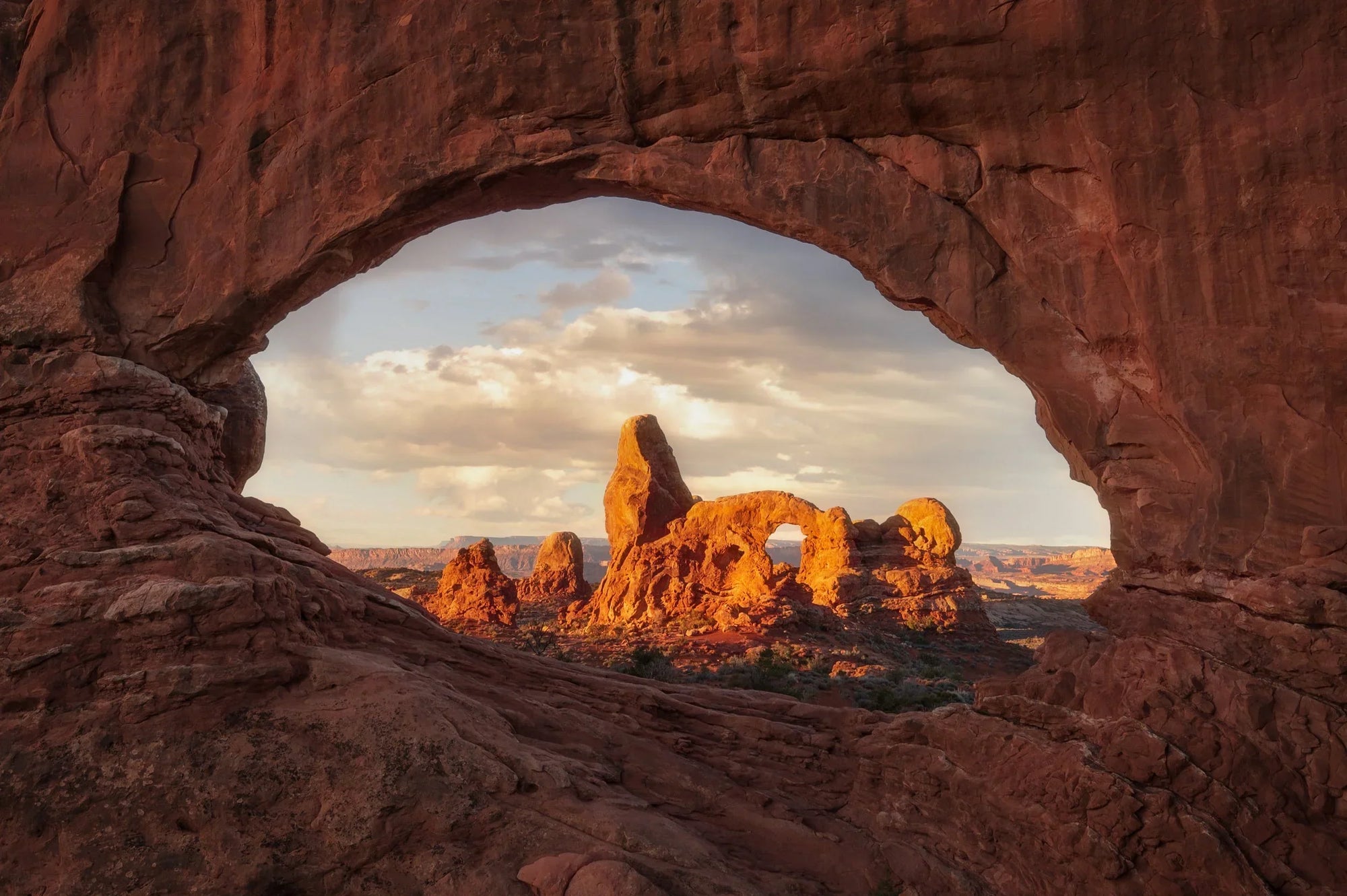North Window framing Turret Arch at sunset in Arches National Park, Utah with glowing red rock formations