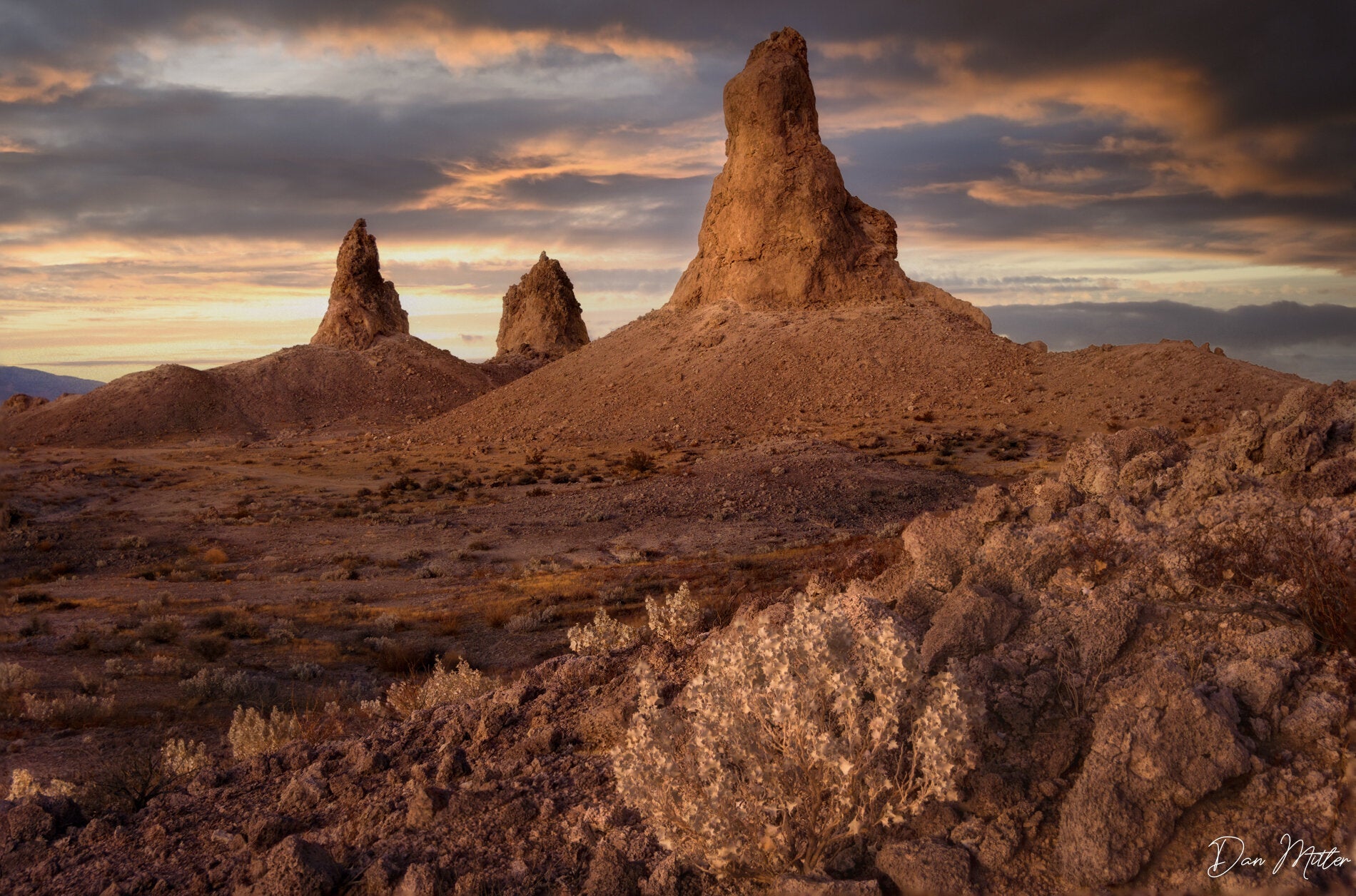 Golden hour light on the Trona Pinnacles in California desert with warm clouds at sunset