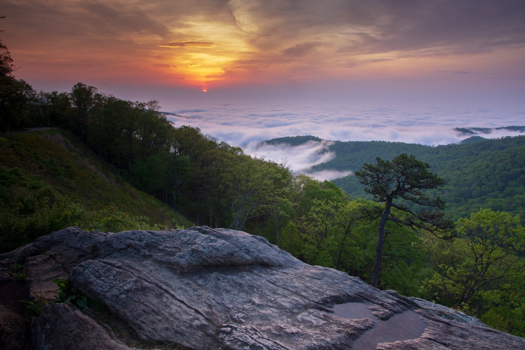Sunrise over rolling Blue Ridge Mountains from rocky overlook in Shenandoah National Park, Virginia